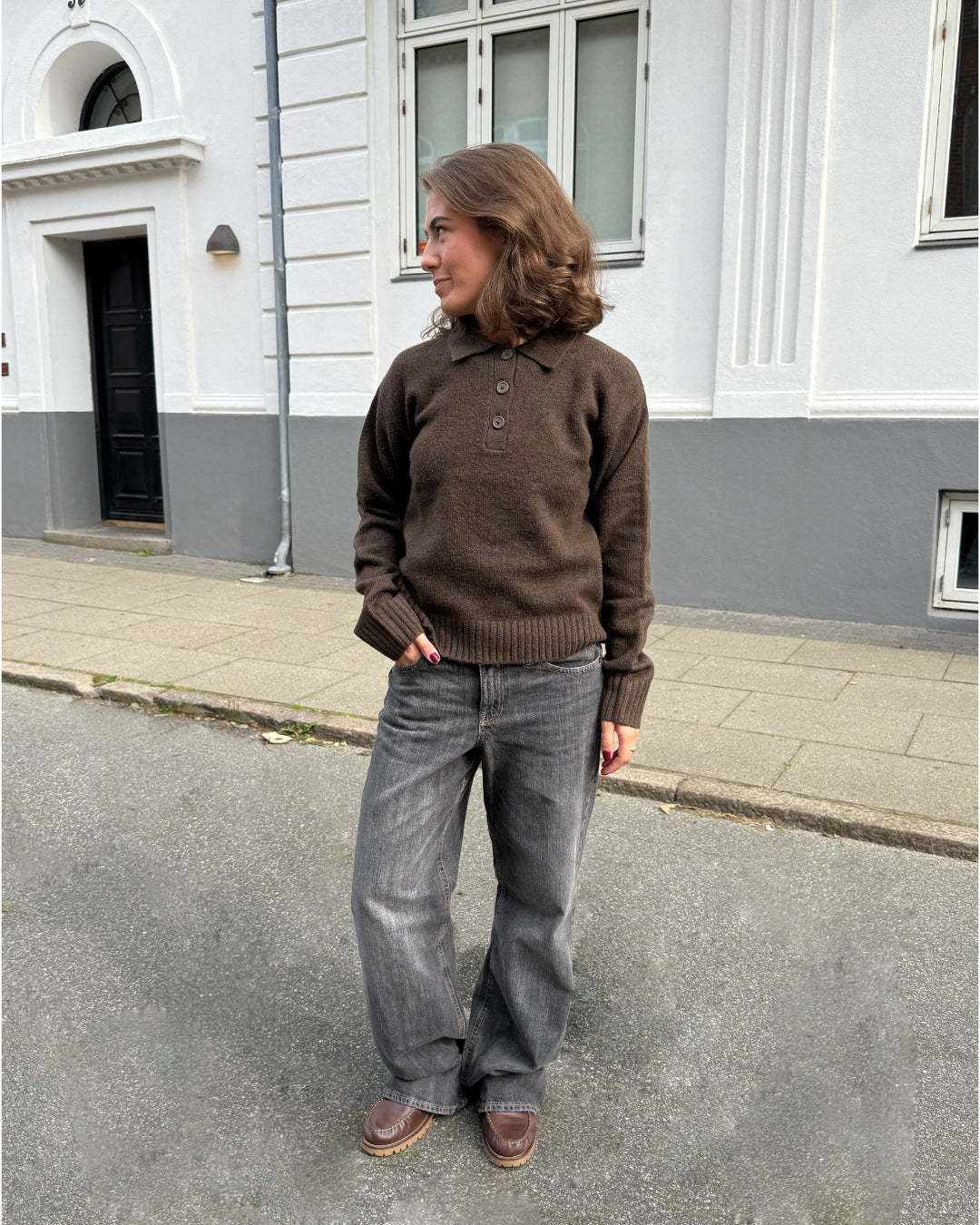 Modelfoto af pige i brun Catalina strik polo, samt grå Nanna jeans. Alt er fra BySofieSønderby