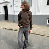 Modelfoto af pige i brun Catalina strik polo, samt grå Nanna jeans. Alt er fra BySofieSønderby