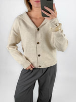 Modelfoto af pige i beige CLARE strik cardigan og grå LISA bukser. Alt er fra BySofieSønderby.