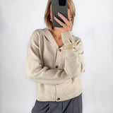 Modelfoto af pige i beige CLARE strik cardigan og grå LISA bukser. Alt er fra BySofieSønderby.