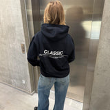 Stemningsbillede af pige der bærer en navy hoodie med hvidt classic tryk og blå NANNA jeans.  Fra BySofieSønderby