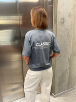 Stemningsbillede af pige der bærer en stone t-shirt med hvidt classic tryk og hvide NANNA jeans.  Fra BySofieSønderby