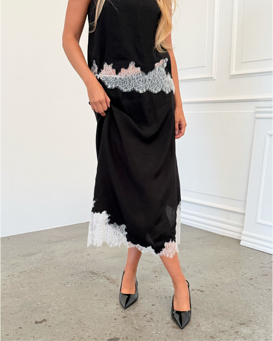 Modelfoto af pige i sort DALME nederdel med hvide blonder, samt matchende DALME top. Alt er fra BySofieSønderby.