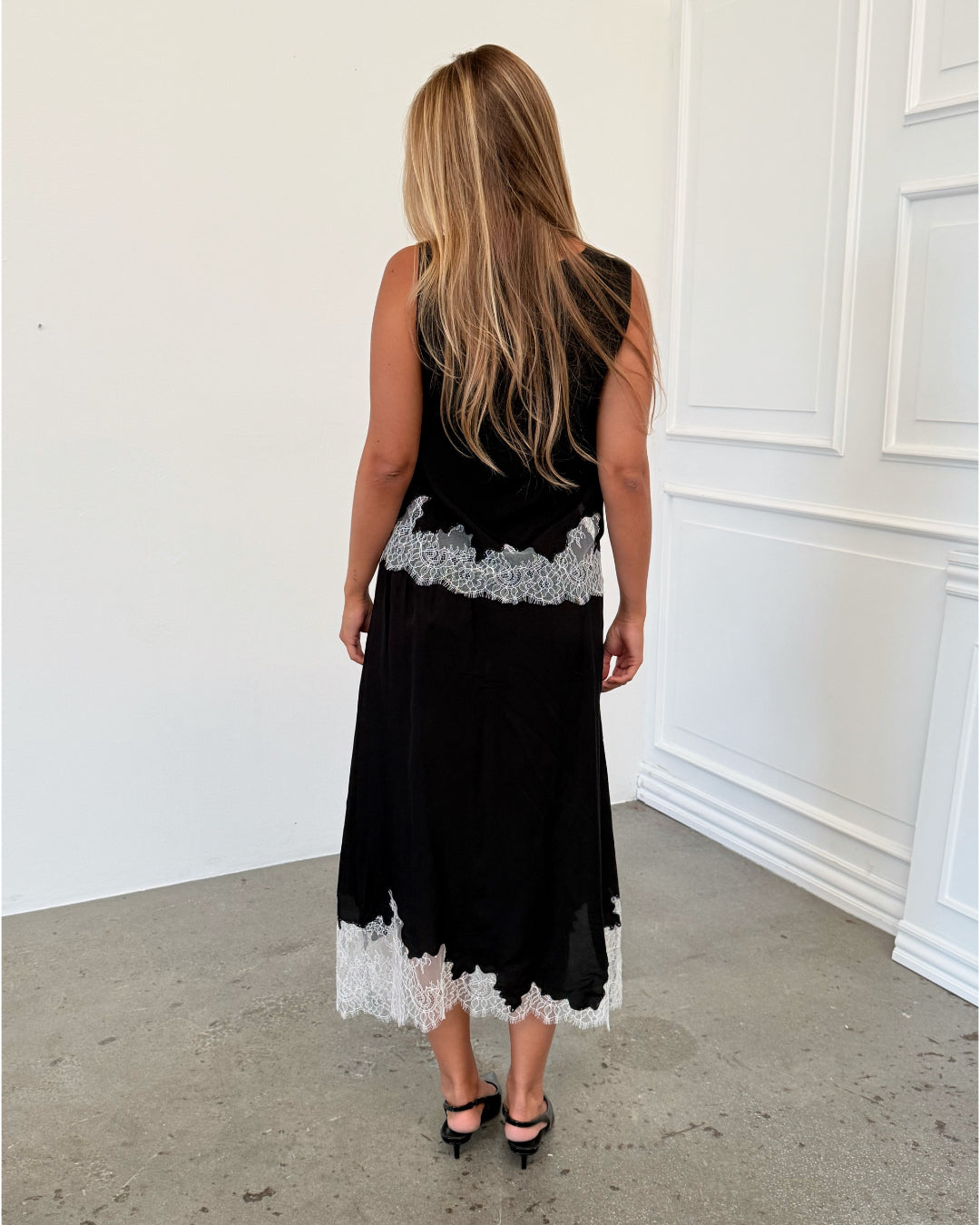 Modelfoto af pige i sort DALME top med hvide blonder, samt matchende DALME nederdel. Alt er fra BySofieSønderby.