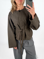 Modelfoto af pige i brun DARLA jakke med bindebånd, samt grå LISA bukser. Alt er fra BySofieSønderby.