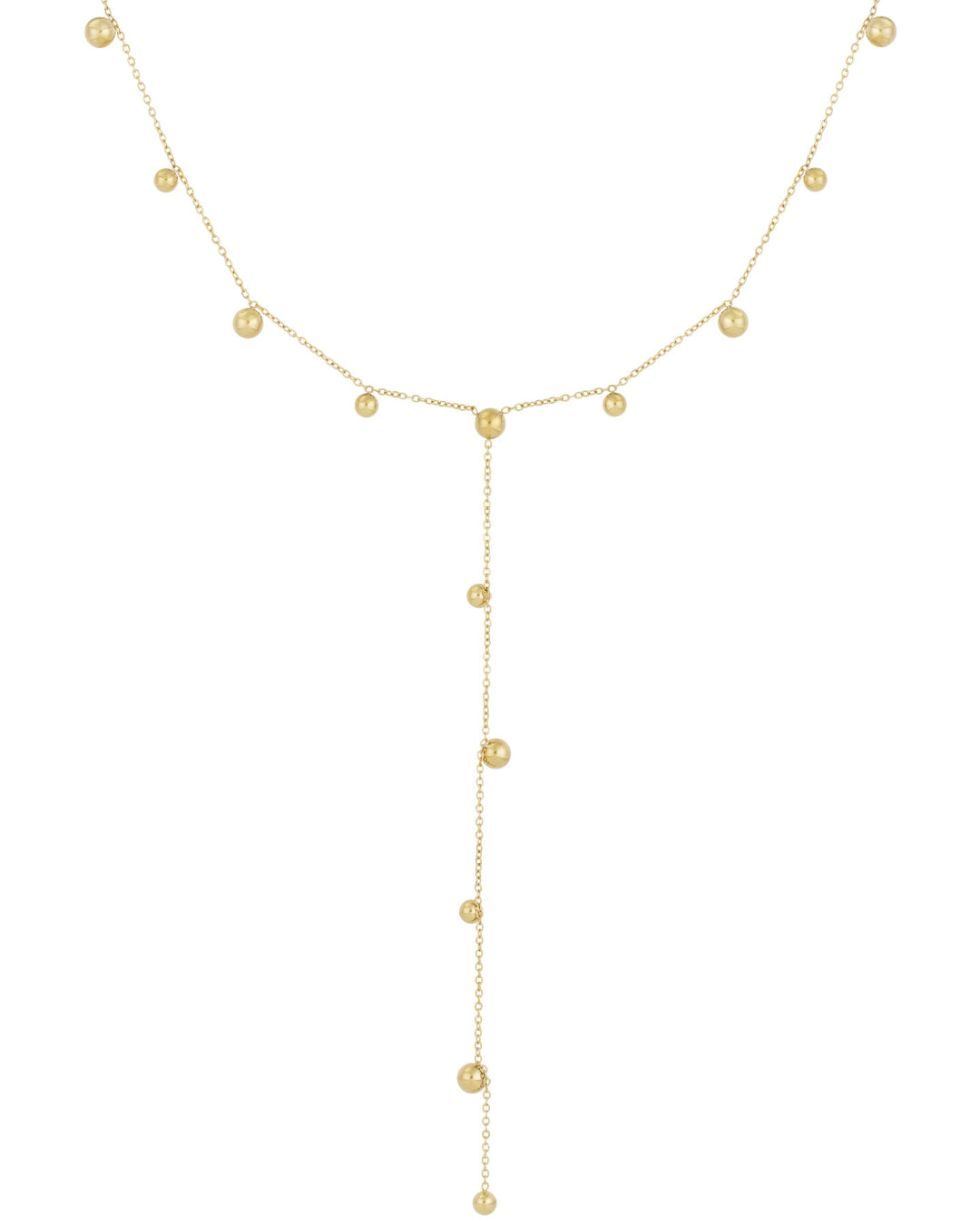 Kæde af guld med små kugler jævnt fordelt; en lang vedhængende sektion hænger centralt. Baggrunden er enkel og hvid, hvilket fremhæver smykkets elegante design.