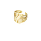 Gylden, åbent armbånd med striberede bånddesign, formet som indviklede linjer omkranser håndleddet. Kontrasterer mod en hvid baggrund. Ingen tekst til stede.