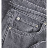 Grå jeans med synlige stikninger og metalnitter, der ligger fladt. Beliggende i en neutral baggrund uden tekst eller detaljer.
