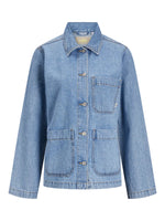 Denimjakke med fire lommer og knaplukning foran; mærkatet JJXX ses ved kraven. Jakken står mod en neutral, hvid baggrund.