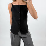 Modelfoto af pige med sort ELLIS top med stropper og knapper, samt grå MILAN bukser. Set forfra. Alt er fra BySofieSønderby