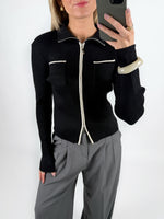 Modelfoto af pige i sort EMRYN zip-strik  og grå LISA bukser. Alt er fra BySofieSønderby.