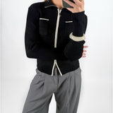 Modelfoto af pige i sort EMRYN zip-strik  og grå LISA bukser. Alt er fra BySofieSønderby.