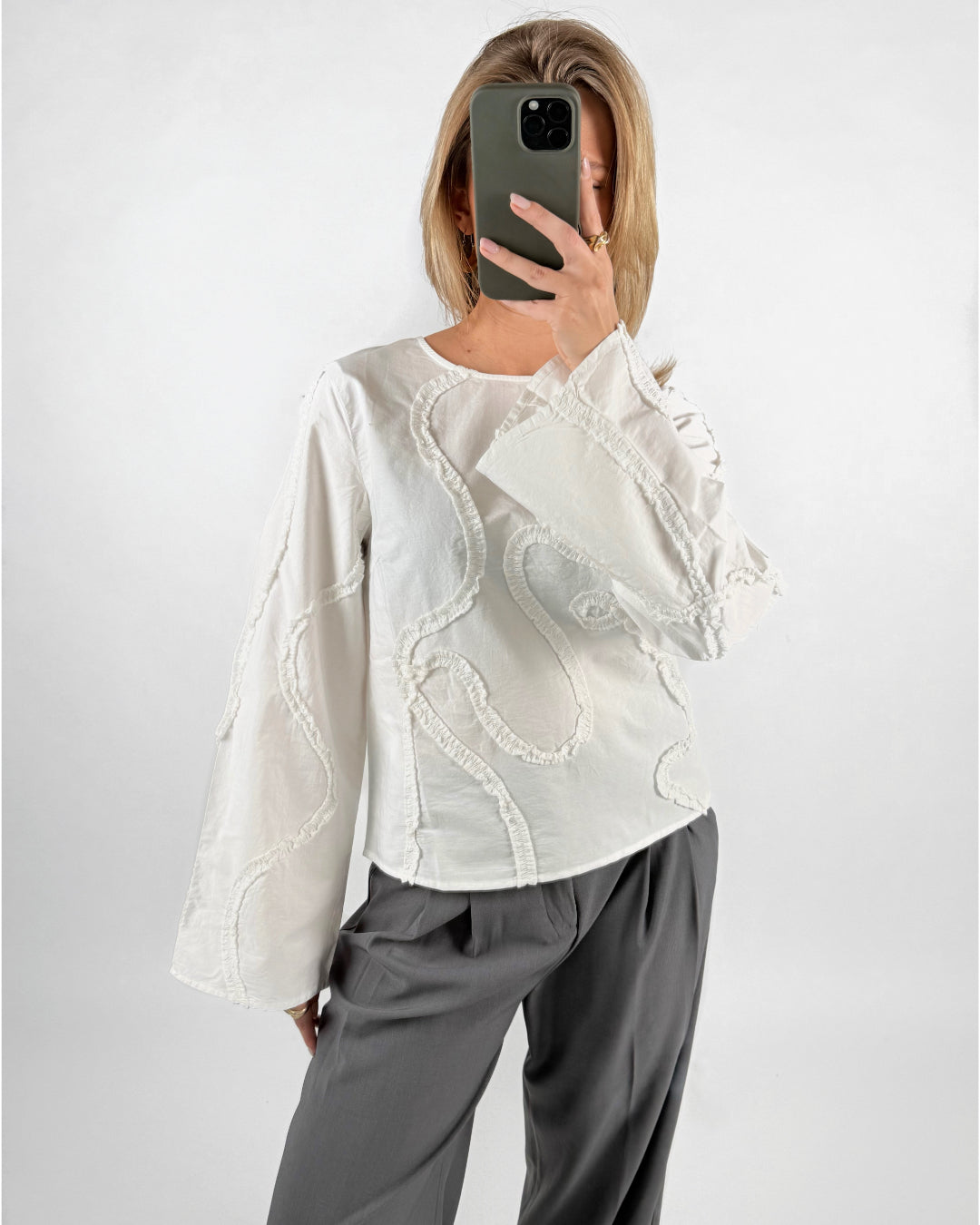 Modelfoto af pige med hvid ENESA skjorte, med detaljer, samt grå MILAN bukser. Set forfra. Alt er fra BySofieSønderby