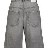 Grå denimshorts hænger med synlige baglommer og bæltestropper i en neutrale baggrund.