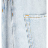 Stoffet er lys denim med gul syning, viser en synlig lomme og en metalknap i øverste venstre hjørne, i en tæt plan flade.