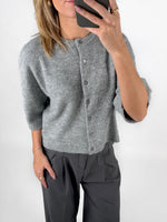 Modelfoto af pige i grå EVI strik t-shirt med knapper og grå LISA bukser. Alt er fra BySofieSønderby.