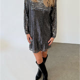 Modelfoto af pige i sølvfarvet FENJA kjole med pailetter, samt sorte støvler. Alt er fra BySofieSønderby.