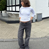 Modelfoto af pige i en hvid Fifi boatneck bluse og grå Nanna jeans. Alt er fra BySofieSønderby