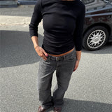 Modelfoto af pige i en sort Fifi boatneck bluse og grå Nanna jeans. Alt er fra BySofieSønderby