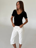 Modelbillede af FINLEY strik t-shirt, sort og VANESSA capri bukser, hvid. Fra BySofieSønderby