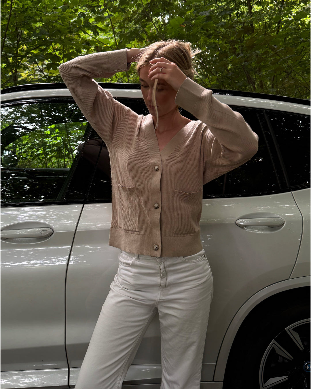 Modelfoto af pige i beige Franciska cardigan og hvide Nanna jeans. Alt er fra BySofieSønderby