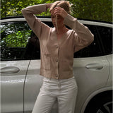 Modelfoto af pige i beige Franciska cardigan og hvide Nanna jeans. Alt er fra BySofieSønderby