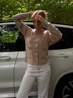 Modelfoto af pige i beige Franciska cardigan og hvide Nanna jeans. Alt er fra BySofieSønderby