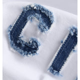 Detaljefoto af hvid Gigi t-shirt med denimblå Ciao bogstaver. På hvid baggrund. Fra BySofieSønderby