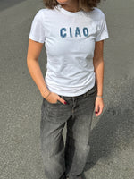 Modelfoto af pige i hvid t-shirt med Ciao syet på brystet, samt grå Palermo jeans. Alt er fra BySofieSønderby