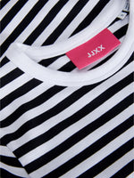 En sort-hvid stribet t-shirt ligger fladt med en lyserød mærkeseddel, hvor der står "JJXX". Den er placeret i en ubrugt, ryddelig kontekst.
