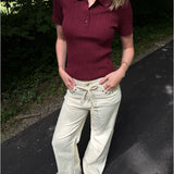 Modelfoto af pige i en bordeaux Hadley polo og cremefarvede Adrianna jeans. Alt er fra BySofieSønderby