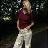 Modelfoto af pige i en bordeaux Hadley polo og cremefarvede Adrianna jeans. Alt er fra BySofieSønderby