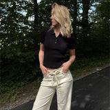 Modelfoto af pige i en sort Hadley polo og cremefarvede Adrianna jeans. Alt er fra BySofieSønderby