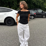 Modelfoto af pige med REYA top, sort og NANNA jeans, hvid - begge fra BySofieSønderby