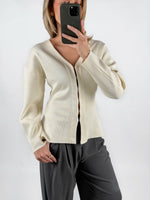 Modelfoto af pige med creme farvet INDY cardigan, samt grå MILAN bukser. Set forfra. Alt er fra BySofieSønderby