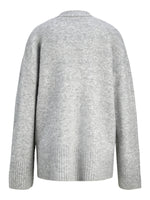 En grå sweater hænger frit, lavet af blødt, strikket materiale. Den har lange ærmer og en ribbet kant ved taljen og ærmeenderne, på en hvid baggrund.