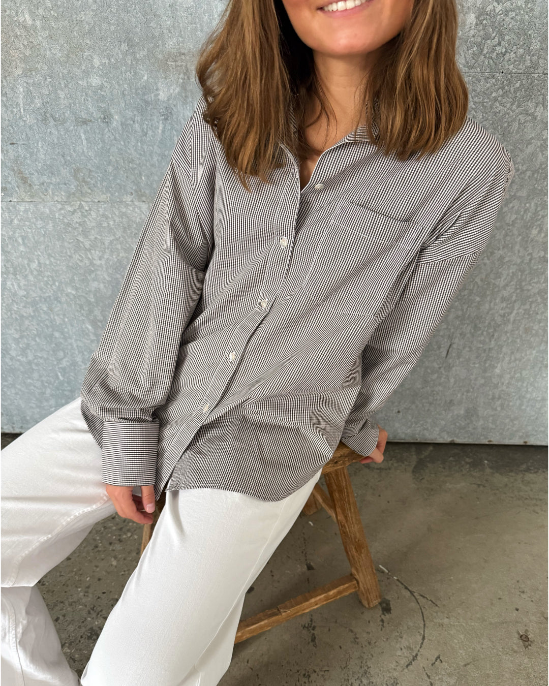 Modelfoto af pige der bærer en brun/hvid ternet Jamie Skjorte, samt hvide Nanna jeans. Alt fra BySofieSønderby