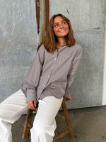 Modelfoto af pige der bærer en brun/hvid ternet Jamie Skjorte, samt hvide Nanna jeans. Alt fra BySofieSønderby