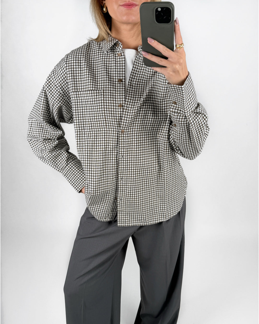 Modelfoto af pige i brun/hvid JAMIE skjorte, samt grå LISA bukser. Alt er fra BySofieSønderby.