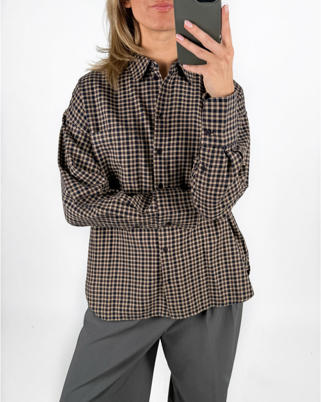 Modelfoto af pige med brun/sort ternet JAMIE skjorte, og grå LISA bukser. Alt er fra BySofieSønderby.