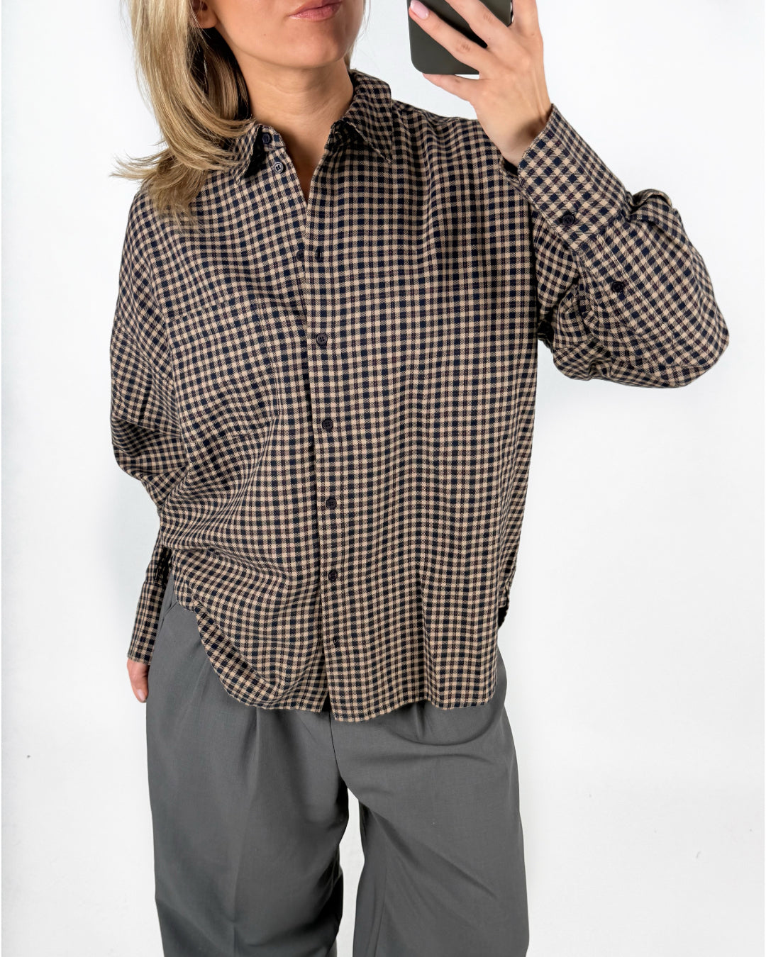 Modelfoto af pige med brun/sort ternet JAMIE skjorte, og grå LISA bukser. Alt er fra BySofieSønderby.