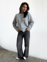 Modelfoto af pige i grå Josie striktrøje, og grå Nanna jeans. Alt er fra BySofieSønderby 