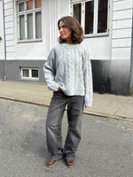 Modelfoto af pige i grå Josie striktrøje, samt grå Palermo jeans. Alt er fra BySofieSønderby