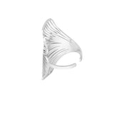 Sølvfarvet ring med buet, skulpturelt design og indgraverede linjer i et mønster. Ringen har en åben, justerbar form og er sat mod en hvid, neutral baggrund.