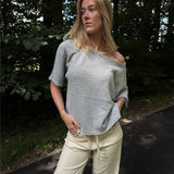 Modelfoto af pige i grå Karsyn wideneck  t-shirt og cremefarvede Adrianna jeans. Alt er fra BySofieSønderby