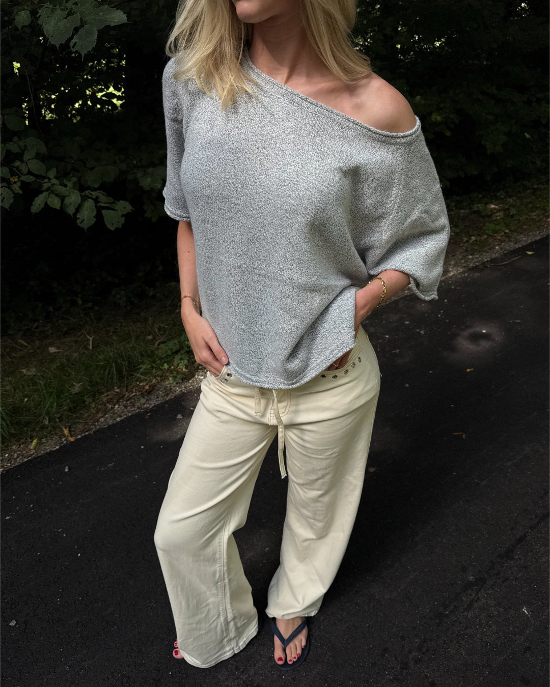 Modelfoto af pige i grå Karsyn wideneck  t-shirt og cremefarvede Adrianna jeans. Alt er fra BySofieSønderby
