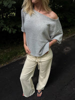 Modelfoto af pige i grå Karsyn wideneck  t-shirt og cremefarvede Adrianna jeans. Alt er fra BySofieSønderby
