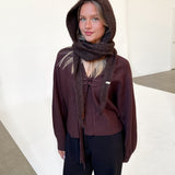 Modelfoto af pige iført brun KATHERINE balaclava, bordeaux cardigan og sortmelerede ELLIS bukser. Alt er fra BySofieSønderby.