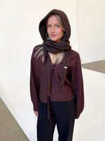 Modelfoto af pige iført brun KATHERINE balaclava, bordeaux cardigan og sortmelerede ELLIS bukser. Alt er fra BySofieSønderby.