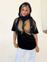 Modelfoto af pige iført navy KATHERINE balaclava, mørkblå t-shirt og hvide NANNA jeans. Alt er fra BySofieSønderby.